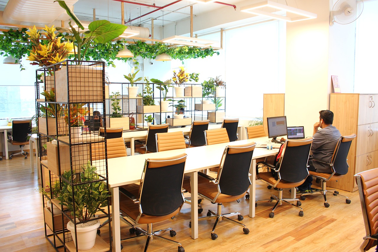 Espace de coworking avec tables, chaises et plantes de décoration